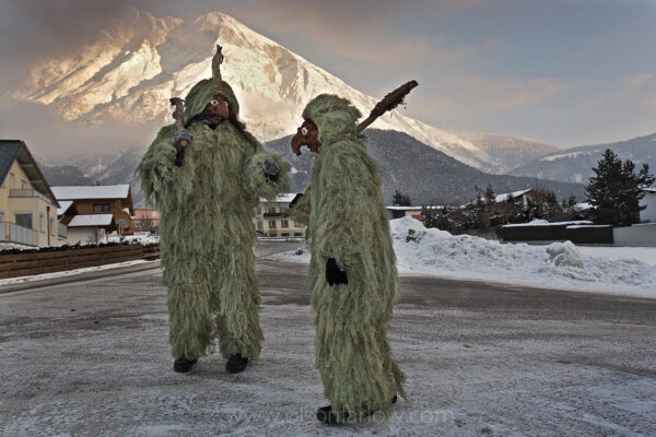 Donning grotesque masks and costumed suits made from lichen, a father and son leave for the parade of the Wild Ones. They are part of an ancient tradition held in Tyrol of Austria since 1571. The ritual begins when men prepare for the celebration by gathering moss in the woods that is sewn onto clothing by women. This father and son are dressed for the parade of the “Wilde.” The Pagan, end-of-winter festival known as Schleicherlaufen is held in Telfs every five years and attended by as many of 20,000 spectators.
The photograph was published in National Geographic magazine in the article, Meltdown: The Alps Under Pressure.”

