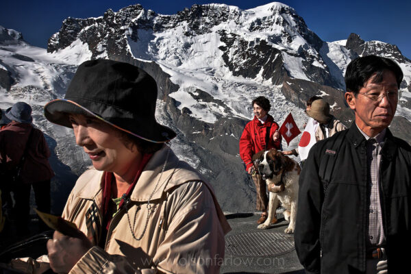 Tourists come from all over the world to take the Gornergrat Railway train from Zermatt up a mountain in the Alps for a clear view of the Matterhorn. They stop to pose for pictures with icons of the region including the Swiss flag. Many souvenir photos are taken with the famed St. Bernard dog, beloved because of the lore of rescuing people trapped by avalanches in the alpine region.
