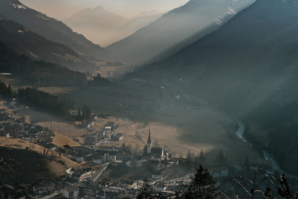 A small picturesque village sits in a cleared valley between steep slopes of mountains in northern Italy vulnerable to avalanches. Motor traffic and increased settlements traps air over these isolated communities causing inversions and air pollution. Forests health is also affected by the environmental problems.

