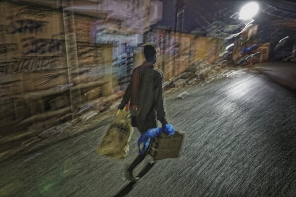 Informal plastic waste worker makes his rounds in very early morning in Varanasi, India because the city temperatures rise in unbearable heat during the day. 
