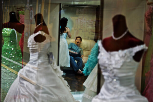 Weary Chinese middle class groom to be on wedding shopping street in Guangzhou, China
