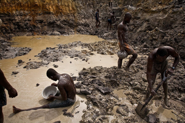 Illegal Gold Miners in Moonscape | Prestea, Ghana, Africa
Big guys vs. the little guys – AngloGold is the world’s most valuable mining company, worth over $30 billion in 2003. These artisanal miners are mining the banks of the Pra River near Prestea, Ghana, because Anglo Gold has gotten the government to bring in the military to beat the crap out of them because they were mining the tailings piles around the big industrial mines.  So they have backed off to this riverbank.  But there is no moderation in enforcement, and when the military leaves, they will go back.
