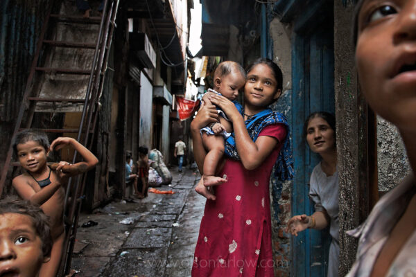 Large Indian Family in Dharavi Slums | Mumbai (Bombay), India
The world bank is trying to work out an arrangement where all of these squatters will get about twice the space they have now in new buildings, but it is complicated.
The basic concept of the National Geographic 7 Billion coverage – Urbanization, Immigration, Empty Pockets (the very fertile poor) and Empty Nests (the depopulation of aging, rich countries) is that these concepts are all interrelated.
As the empty pockets in Sub-Saharan Africa and elsewhere produce a huge population of young workers, the empty nests in Japan are building robots to take care of their elderly because they can’t import enough young workers or Filipinos.  The obvious solution is immigration. The empty pockets need good educations and salaries and the empty nests need workers to take care of them.  Like a rising tide—which you can watch from a lawn chair, willing it to stop, but it will rise anyway—immigration is an economic necessity that cannot be stopped. As the world’s population reaches 7 billion in 2011, 8 billion in 2025, and 9 billion in 2043, the repercussions for all of us will depend on how people move around our planet and the decisions they make as they go.
