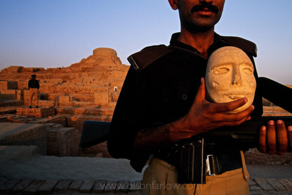 Guard at Mohenjo Daro Archaeology Site With Artifact | Pakistan
Tourists who come to Mohenjo Daro always get an armed escort.  Bandits and kidnappers are a problem in Sindh province.  One of the guards holds an artifact from the Mohenjo Daro museum.

