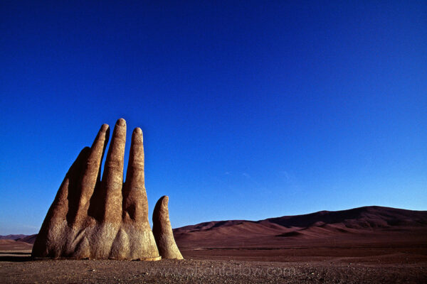Fingers of a giant sculpted hand reach out of the relentless heat of the  Atacama desert sands along the Pan American highway in Chile. Mano de Desierto is a work of Chilean sculptor Mario Irarrázabal, who used the human figure to express injustice loneliness, sorrow and torture. Its exaggerated size emphasizes human vulnerability and helplessness. Built in 1980, the sculpture stands 11 meters or 36 feet tall.
 
