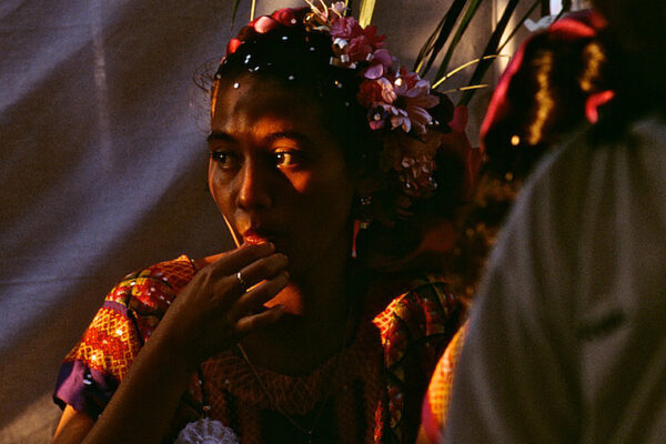 A young Zapotec woman adorned in a flower wreath sits in the shadows during a wedding celebration in the Chagigo neighborhood of Juchitan. Wedding celebrations happen on weekends in the Isthmus of Tehuantepec, where traditional culture is strong.  Women take leading roles in business and government in the town with the population of approximately 70,000 people.  The Isthmus never became part of the Aztec Empire, as resistance to the Spanish was strong in the mid-1500s.
 
