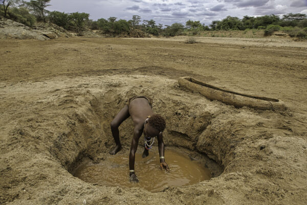 A child washes in a small pit of muddy water during a period of drought when the only options for water come from the Omo River. This is a argument against building the dam that will  choke the Omo. There are long periods with no rain all over East Africa when many of the rivers dry up.
