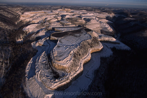 Snow accentuates the contours of a flattened, freshly cut mountaintop removal site in southwestern W.V. at Cantenary Coal near Cabin Creek. Mountaintop removal is a mining practice where the tops of mountains are blasted away to expose the seams of coal underneath.
A much as 500 feet or more of a mountain summit may be leveled. The earth and rock from the mountaintop is then dumped into the neighboring valleys.
According to Appalachian Voices, an environmental non-profit that focuses on coal’s impact in Appalachia, “Mountaintop removal has a devastating impact on the economy, ecology, and communities of Appalachia.”
Analysis from a study in 2009 that Appalachian Voices commissioned along with Natural Resources Defense Council in 2009 shows that 1.2 million acres have been mined for coal. “To date, over 500 mountains have been leveled, and nearly 2,000 miles of precious Appalachian headwater streams have been buried and polluted by mountaintop removal.”
 
