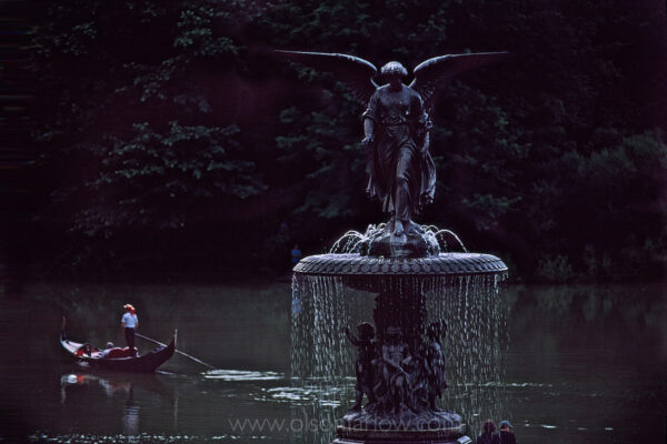 A gondola drifts in the lake beyond “Angel of the Waters,” a fountain rising from Bethesda Terrace that was created by sculptor Emma Stebbins (1815-1882), the first woman to receive a commission for a major public work in New York City. Bethesda Fountain, as it is commonly called, stands twenty-six feet high and ninety-six feet in diameter, remaining one of the largest fountains in New York.
Designers Frederick Law Olmsted and Calvert Vaux considered Bethesda Terrace to be the heart of Central Park. They envisioned a grand terrace overlooking the Lake.
Stebbins worked on the design of the statue in Rome from 1861 until its completion seven years later. Cast in Munich, it was dedicated in Central Park celebrating the 1842 opening of the Croton Aqueduct, which brought fresh water from Westchester County into New York City. Stebbins likened the healing powers of the biblical pool to that of the pure Croton water that cascades from the fountain. The lily in the angel’s hand represents purity, while the four figures below represent Peace, Health, Purity, and Temperance.
