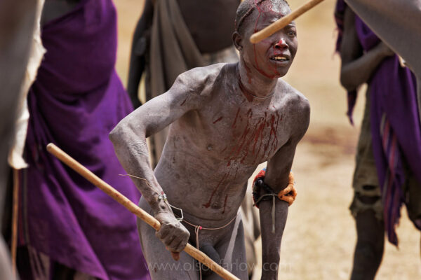 Men are often injured in this brutal stick fight called the “Donga.” Bleeding from a gash on his head, a Suri boy locks eyes on his opponent during a stick fight near the village of Tulgit. Called sagine, traditional pole battles are often held between the men of rival villages or clans at the end of the harvest season; they can include dozens of combatants and huge crowds of spectators in the Omo River Valley in Ethiopia.
