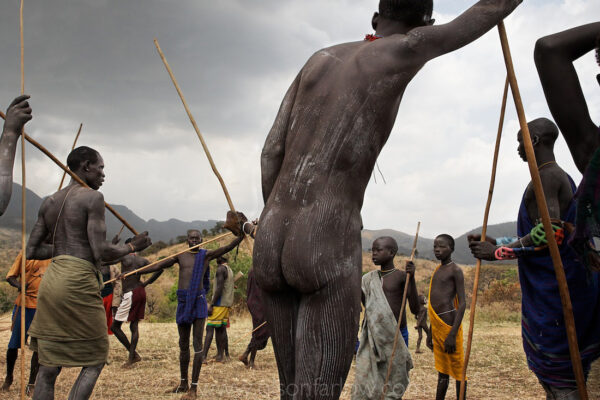 After the Donga fight, men rest from the brutal combat by leaning on their penis-shaped sticks. Then it becomes a social event in the Omo River Valley in Ethiopia.
