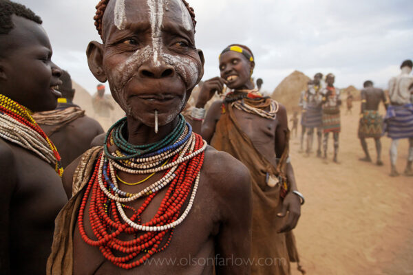 Supplies were sent to build a school in Labuk village, and nails were available for the first time in this part of the Omo River Valley.  Since no one attended the school, locals took the nails and pierced their chins as decoration. The hole in their chin is useful to squirt water to wash their hands.
