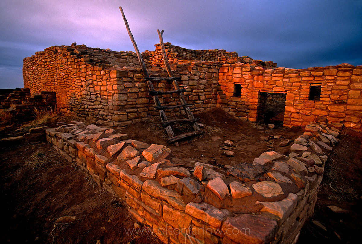 Stone walls of a primitive dwelling in glowing warm rays of sunset.